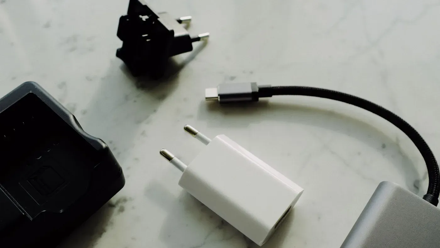 Vit laddare och USB-kabel på en marmorskiva
